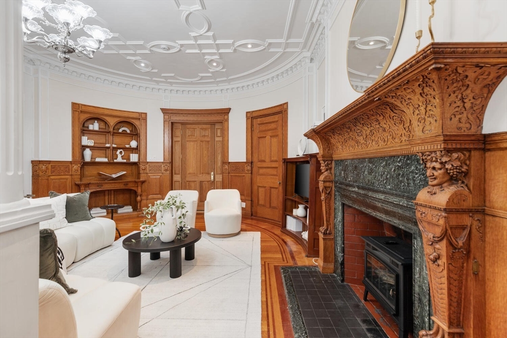 261 Marlborough Street, Unit 4R Boston, MA 02116 - Photo 10 of 36 a living room with furniture a chandelier and a fireplace