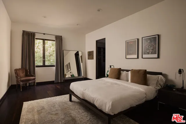 a bedroom with a bed a couch and a large window