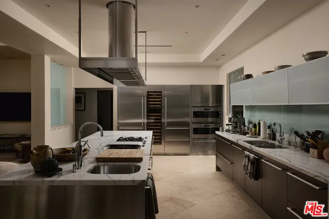 a kitchen with stainless steel appliances a stove a sink and a refrigerator