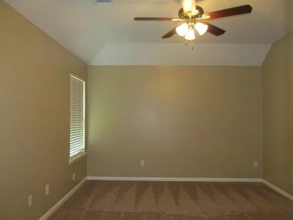 en empty room with windows and fan