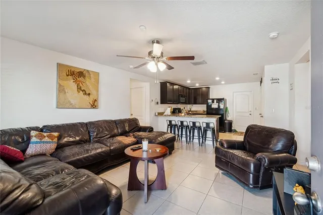 a living room with furniture and a view of kitchen