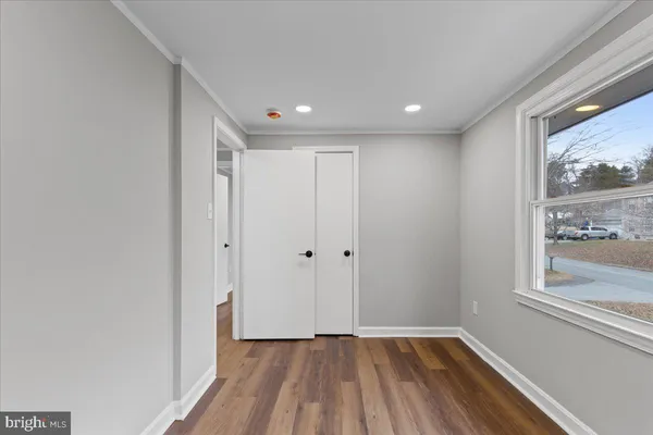 a view of hallway with a large window and wooden floor