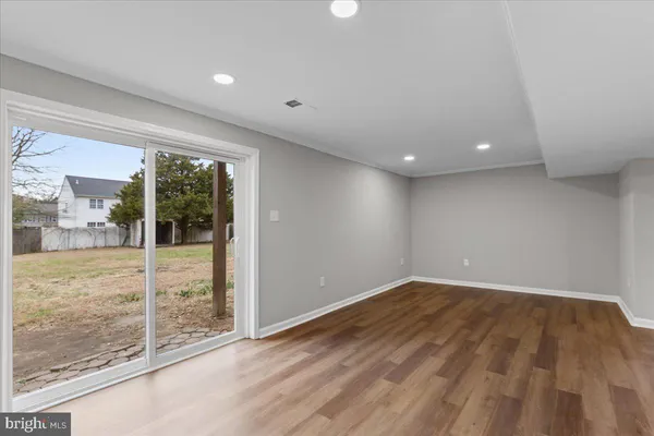 en empty room with wooden floor and windows