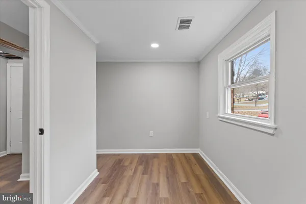a view of empty room with wooden floor