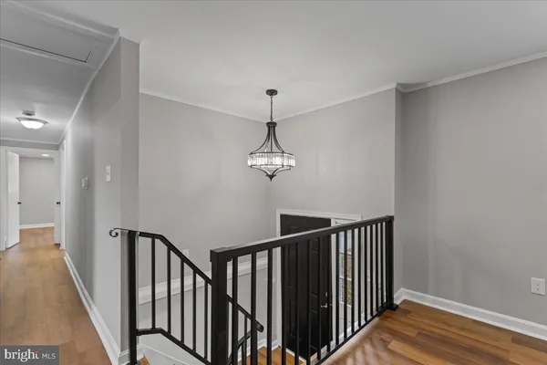 a view of a hallway with wooden floor and stairs