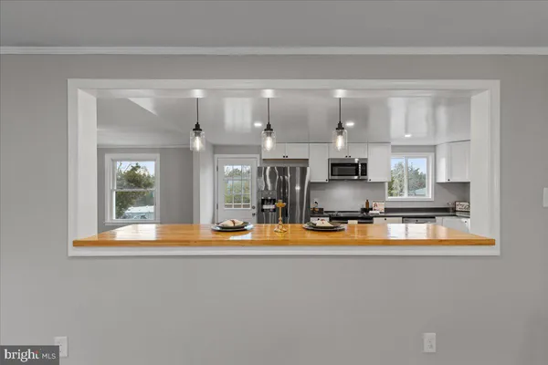 a view of kitchen with living room and refrigerator