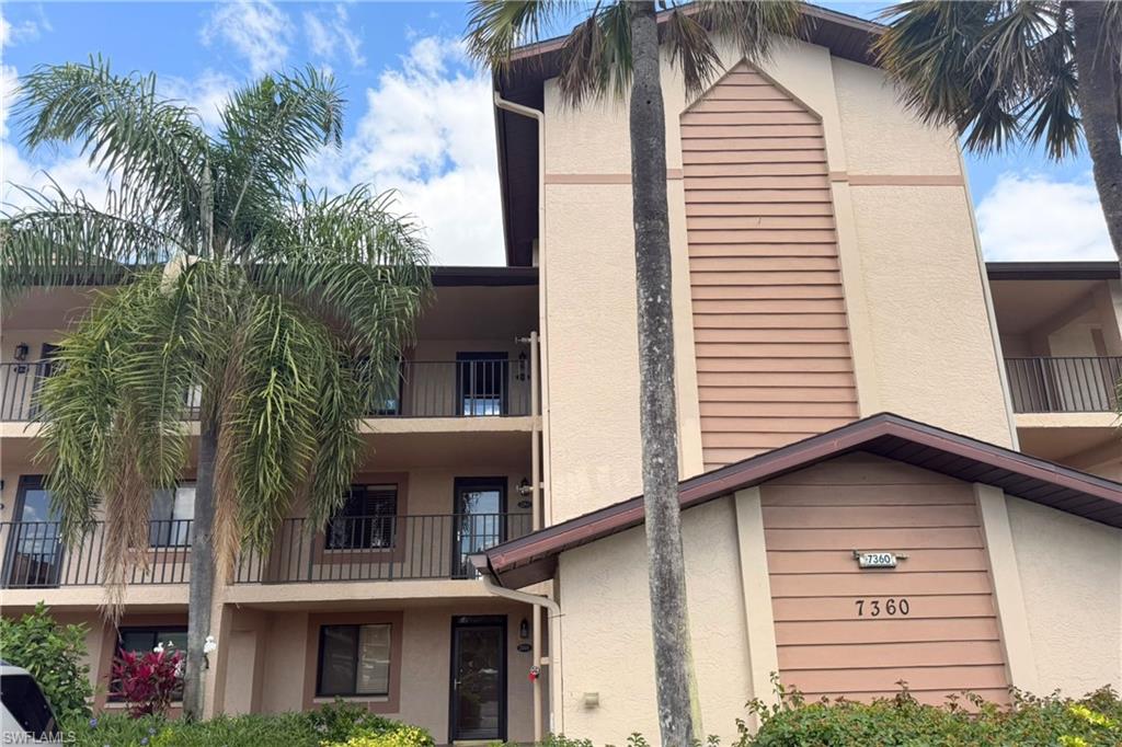 7360 St Ives Way, Unit 2205 Naples, FL 34104 - Photo 1 of 37 a view of a house with a yard and palm trees