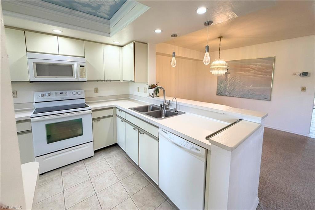 7360 St Ives Way, Unit 2205 Naples, FL 34104 - Photo 11 of 37 a kitchen that has a sink a stove and a microwave