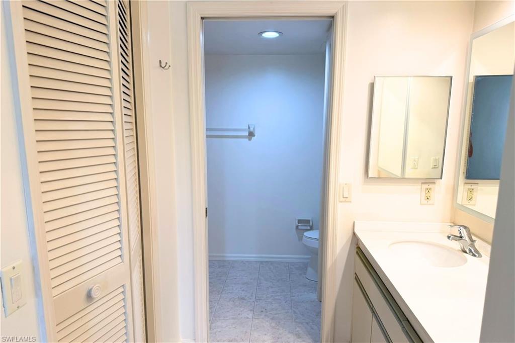 7360 St Ives Way, Unit 2205 Naples, FL 34104 - Photo 22 of 37 a bathroom with a granite countertop sink and a mirror