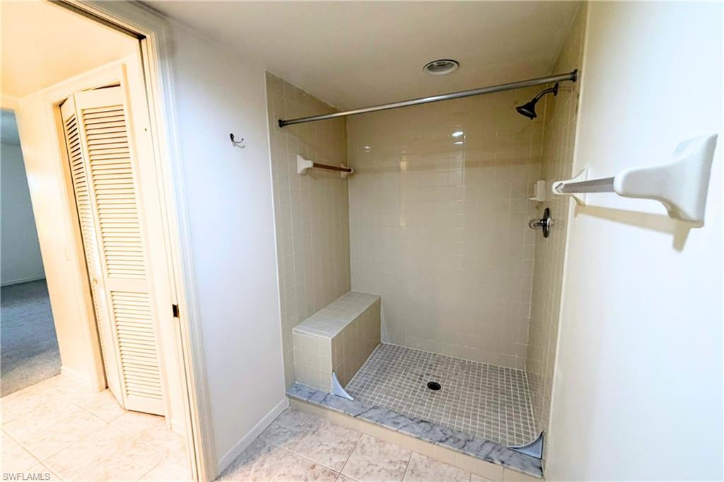 7360 St Ives Way, Unit 2205 Naples, FL 34104 - Photo 27 of 37 a bathroom with a glass shower door