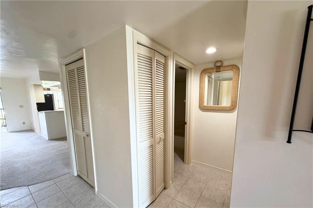 7360 St Ives Way, Unit 2205 Naples, FL 34104 - Photo 28 of 37 a view of a hallway with wooden floor and a bathroom