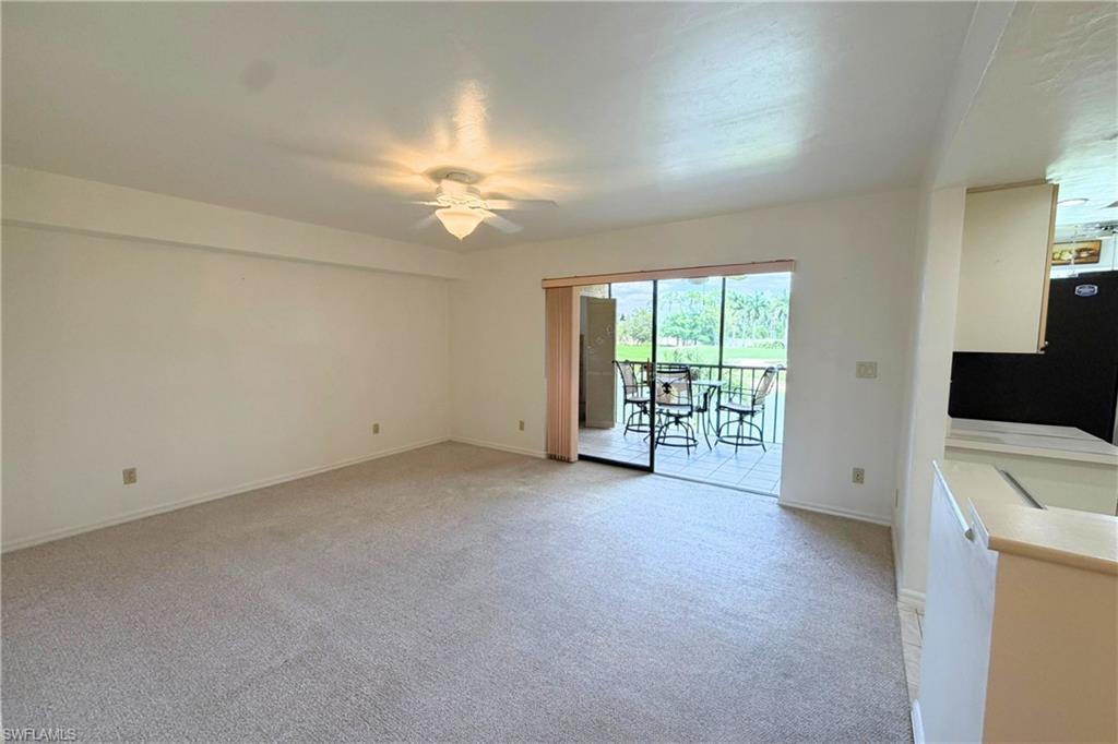 7360 St Ives Way, Unit 2205 Naples, FL 34104 - Photo 3 of 37 an empty room with chandelier fan and windows