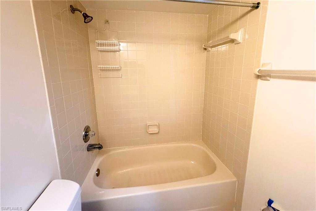 7360 St Ives Way, Unit 2205 Naples, FL 34104 - Photo 32 of 37 a white bath tub sitting next to a toilet