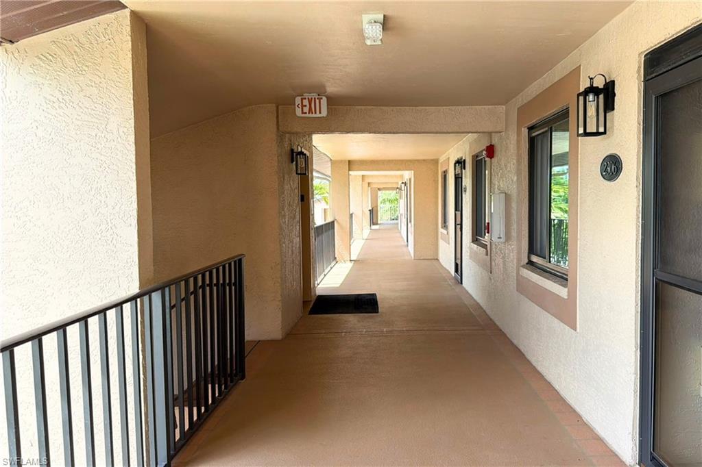 7360 St Ives Way, Unit 2205 Naples, FL 34104 - Photo 33 of 37 a view of a hallway with wooden floor and staircase
