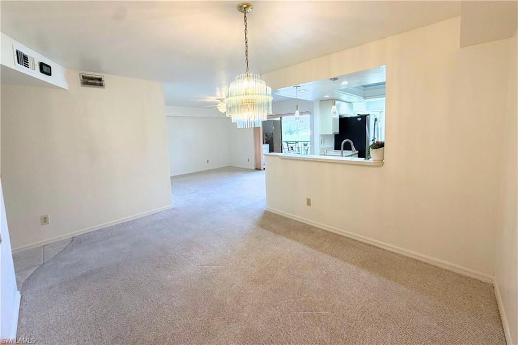 7360 St Ives Way, Unit 2205 Naples, FL 34104 - Photo 6 of 37 a view of a kitchen with a sink and a chandelier