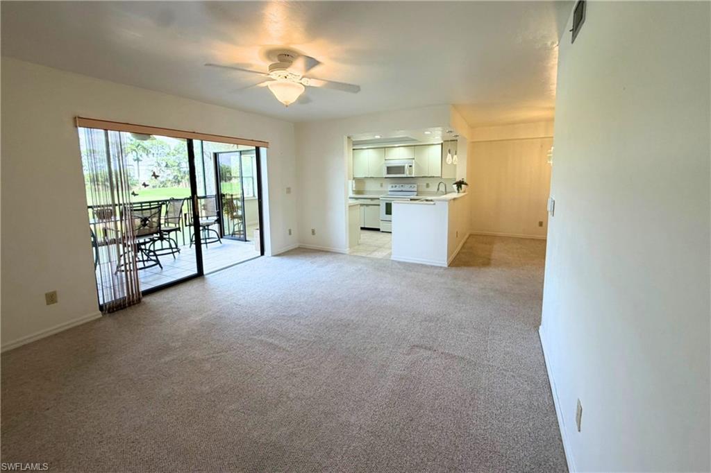 7360 St Ives Way, Unit 2205 Naples, FL 34104 - Photo 8 of 37 an empty room with windows and ceiling fan