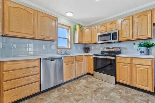 a kitchen with stainless steel appliances granite countertop a stove a sink dishwasher and a microwave oven with cabinets
