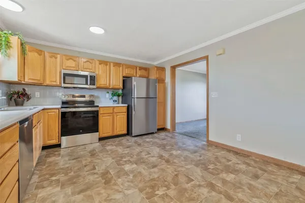 a kitchen with granite countertop a refrigerator and a stove top oven