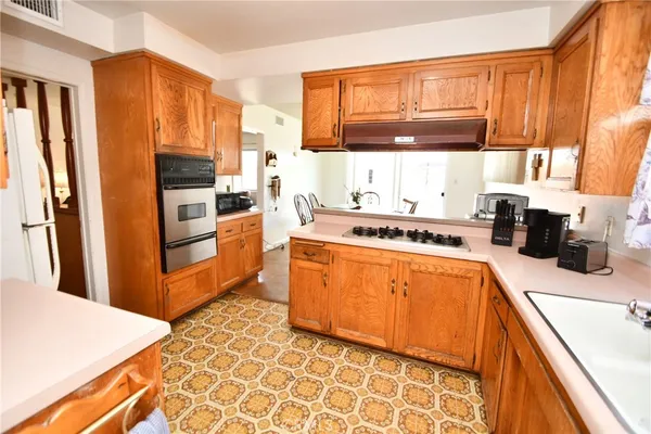 a kitchen with stainless steel appliances granite countertop a refrigerator a stove a sink and dishwasher