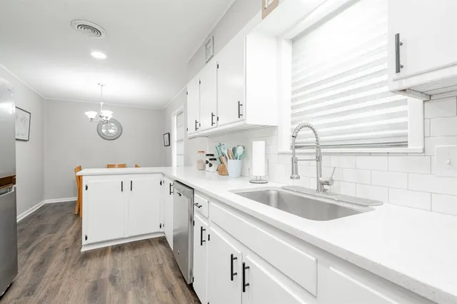 a kitchen with a sink a stove and cabinets