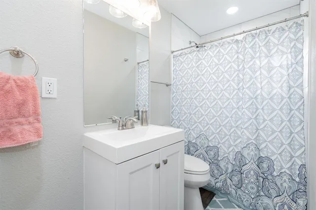 a bathroom with a sink a toilet and shower curtain