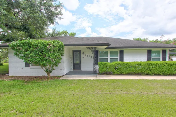 a front view of a house with a garden and yard