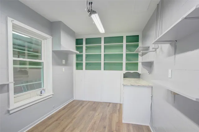 a view of a kitchen with wooden floor and a window