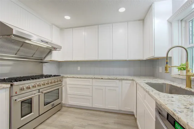 a kitchen with white cabinets stainless steel appliances and sink