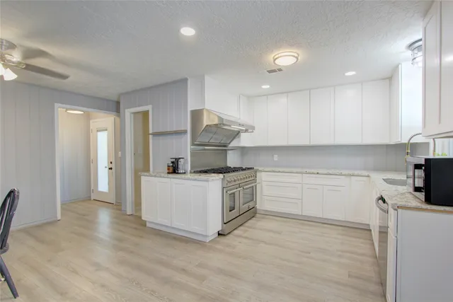 a kitchen with a white stove top oven and white cabinets