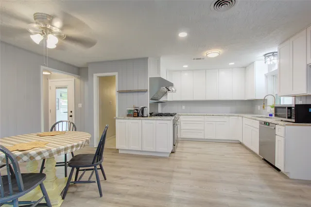 a kitchen with a table chairs stove and cabinets