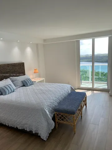 a spacious bedroom with a bed and wooden floor