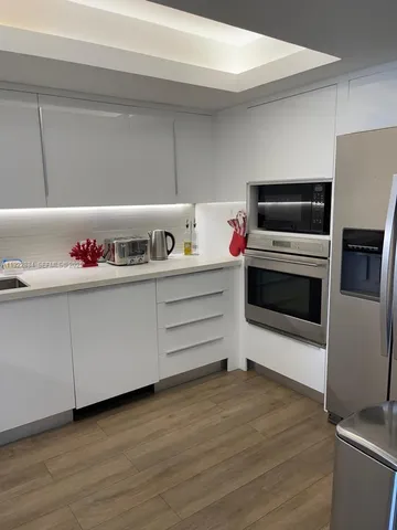 a kitchen with a wooden floor and cabinets