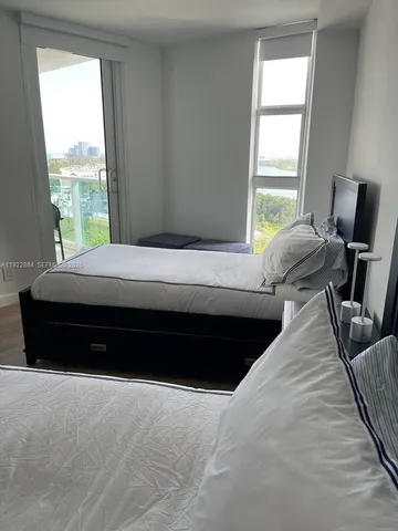 a bed sitting in a bedroom next to a window
