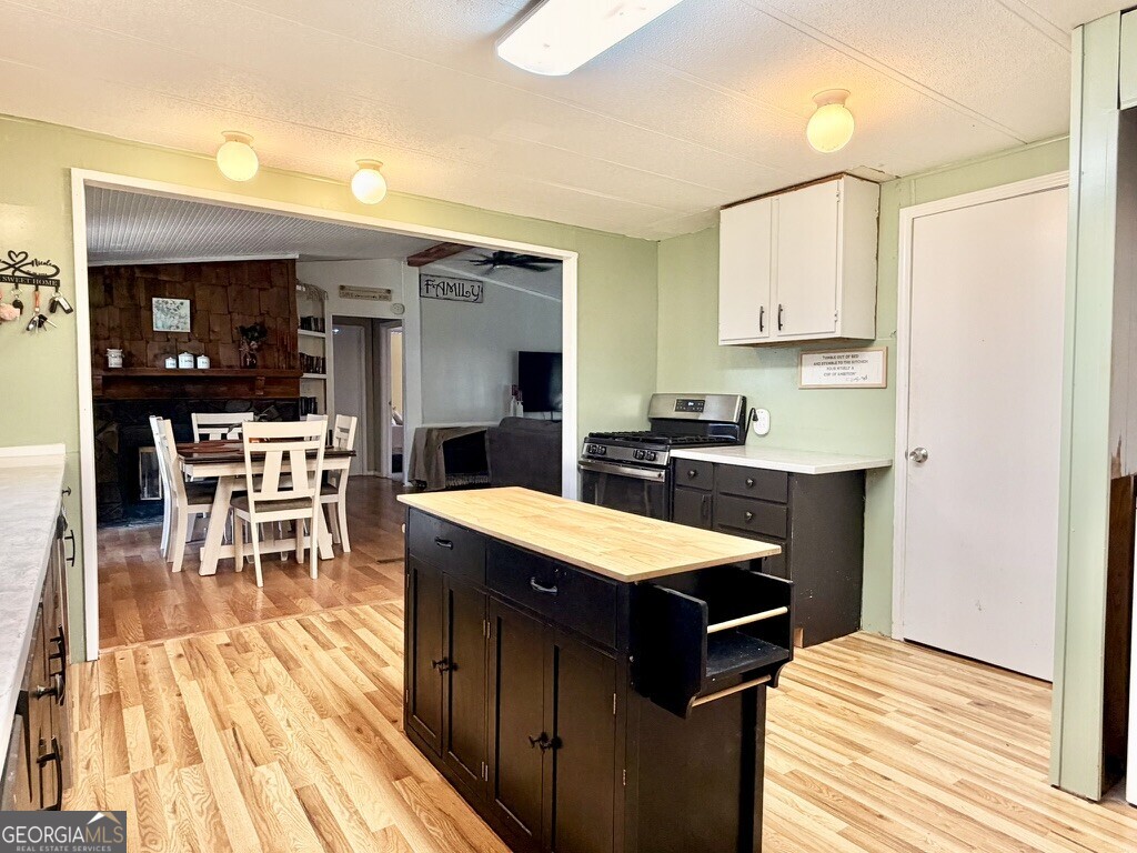 94 Country Place Temple, GA 30179 - Photo 23 of 36 a open kitchen with stainless steel appliances granite countertop a stove top oven a sink dishwasher white cabinets and chairs with wooden floor