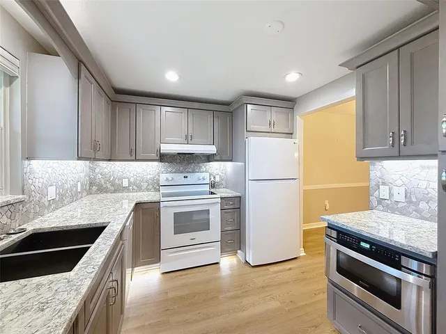a kitchen with granite countertop stainless steel appliances and wooden cabinets