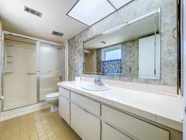 a spacious bathroom with a shower sink and toilet
