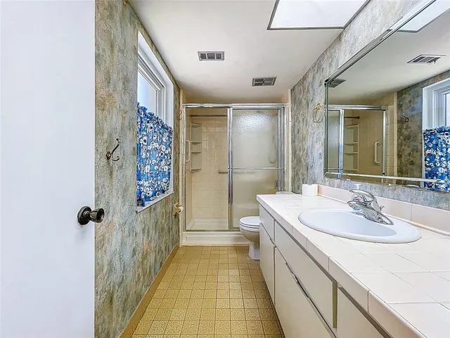 a bathroom with a sink a mirror and a shower