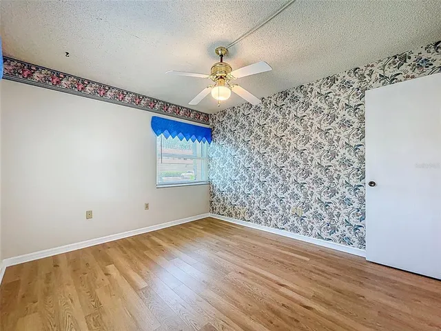 a view of a big room with wooden floor closet and windows