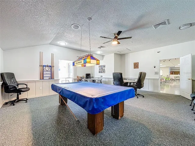 a room with pool table and windows