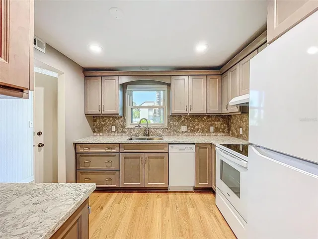 a kitchen with stainless steel appliances granite countertop a stove and white cabinets
