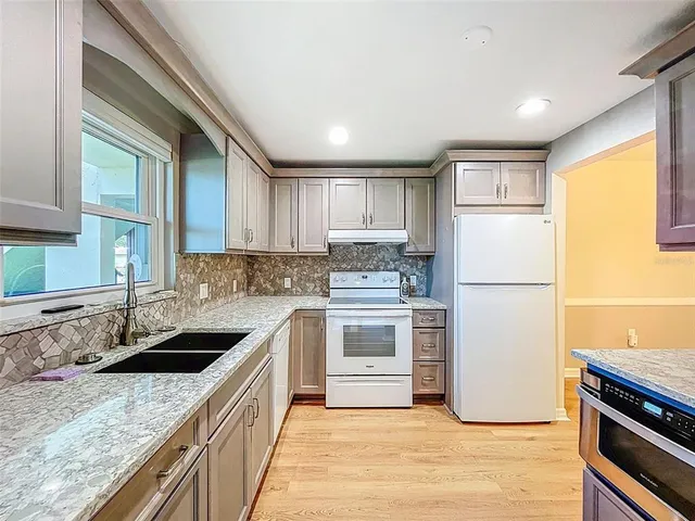 a kitchen with a sink stove and refrigerator