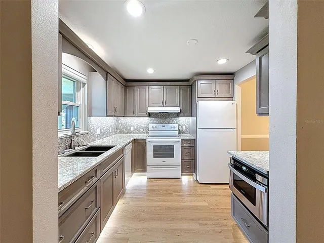 a kitchen with a stove a sink and a refrigerator