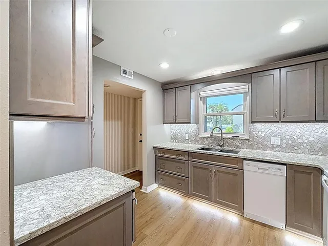 a kitchen with sink cabinets and wooden floor