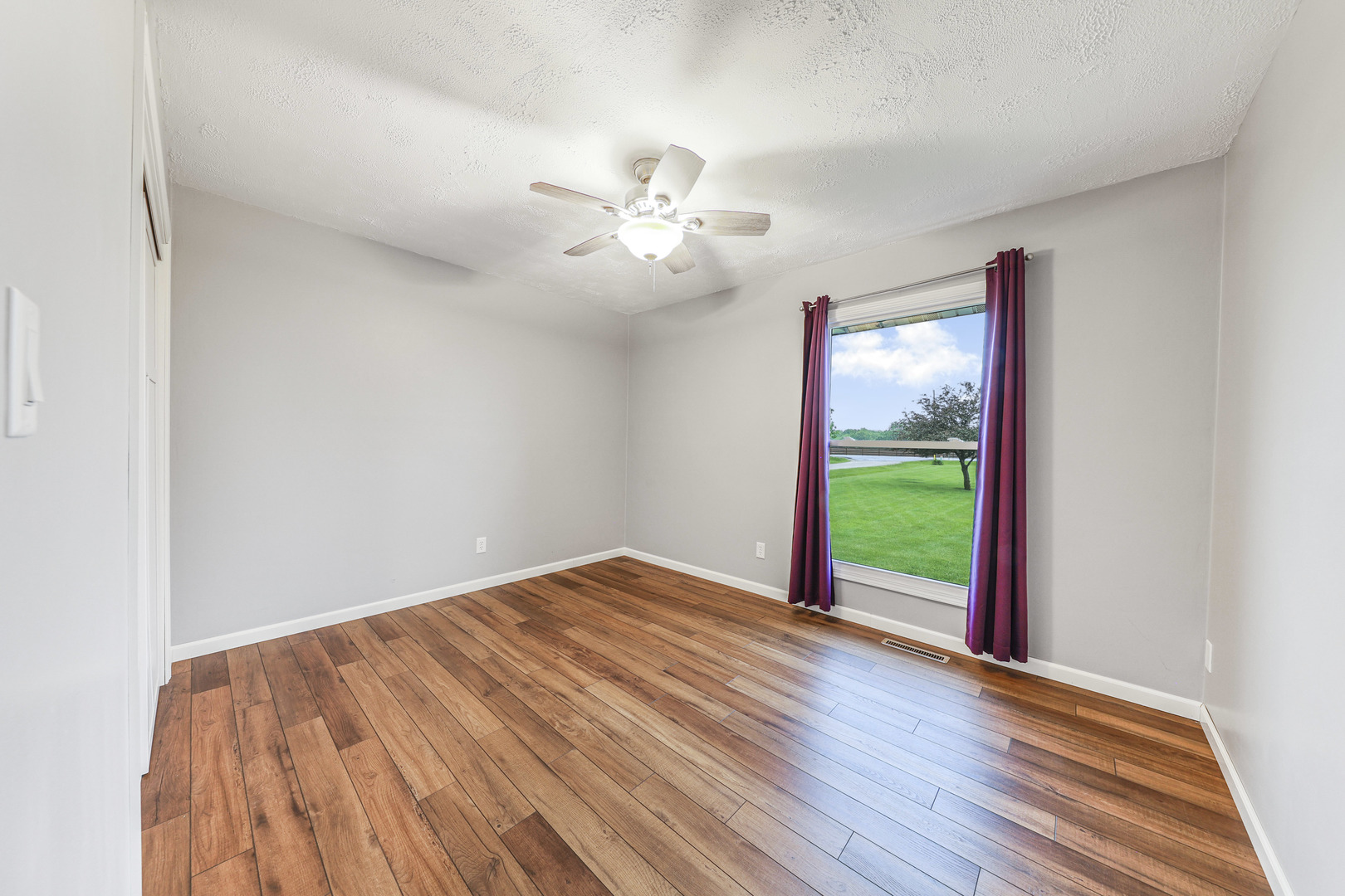 2433 East 2850th Road Marseilles, IL 61341 - Photo 9 of 20 a view of an empty room with a window and wooden floor