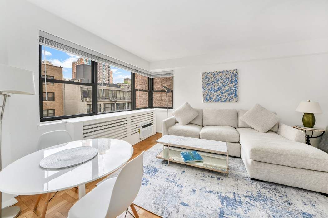 305 East 72nd Street, Unit 5AS Manhattan, NY 10021 - Photo 1 of 11 a living room with furniture and a large window