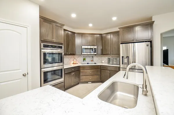 a kitchen with kitchen island a large counter top space appliances and cabinets