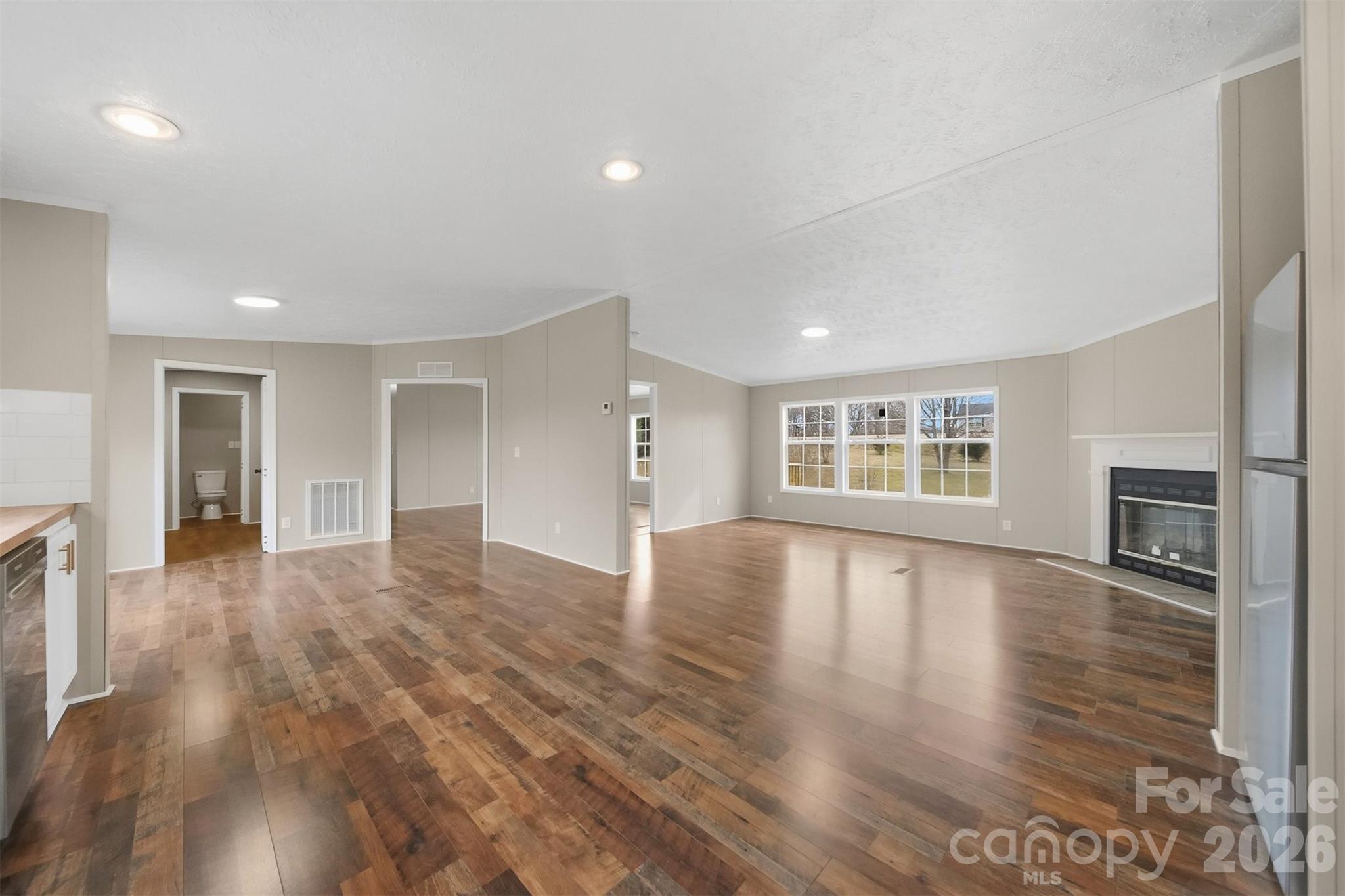 3150 Cranberry Road Boonville, NC 27011 - Photo 12 of 45 an empty room with wooden floor and fireplace