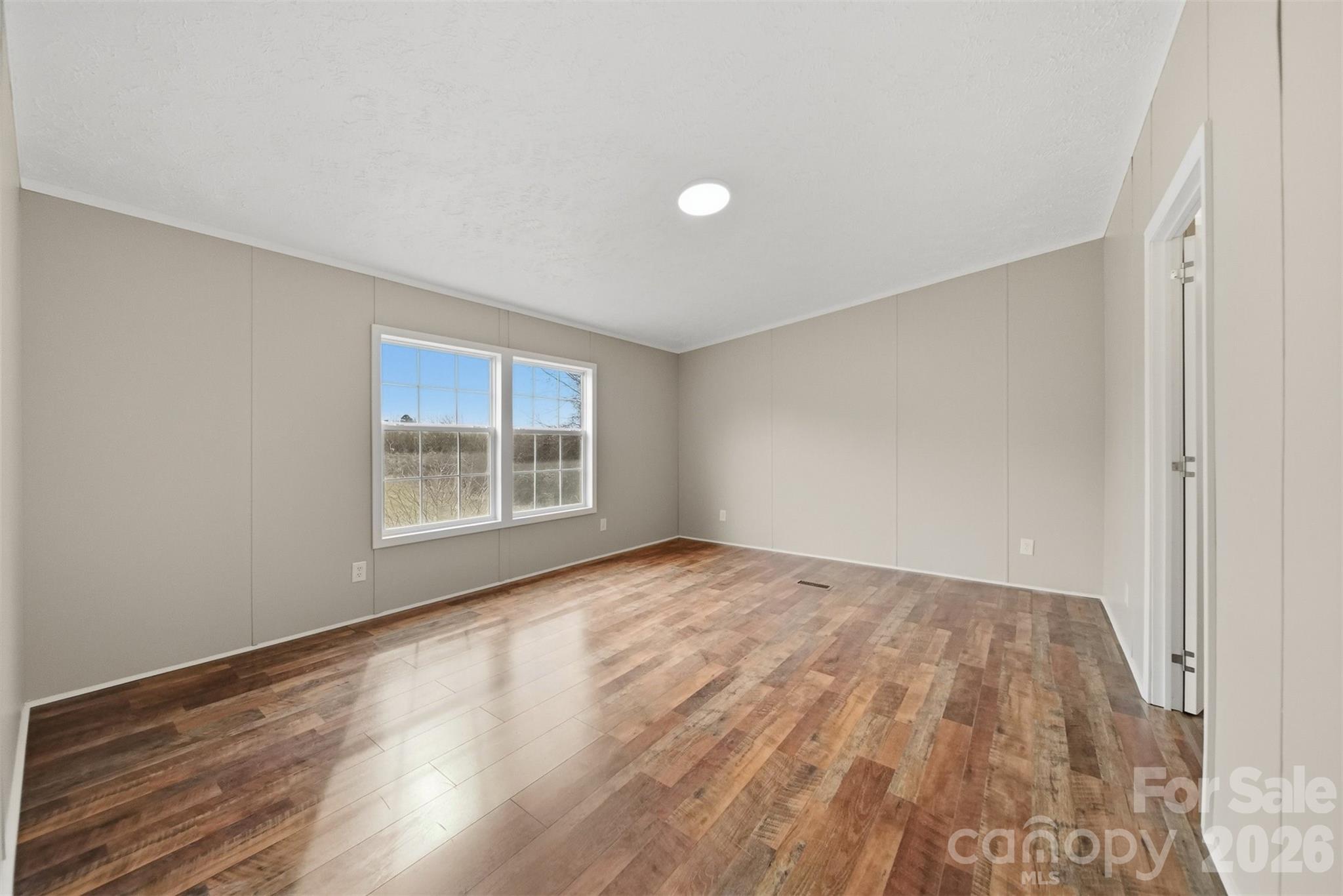 3150 Cranberry Road Boonville, NC 27011 - Photo 21 of 45 a view of an empty room with wooden floor and a window