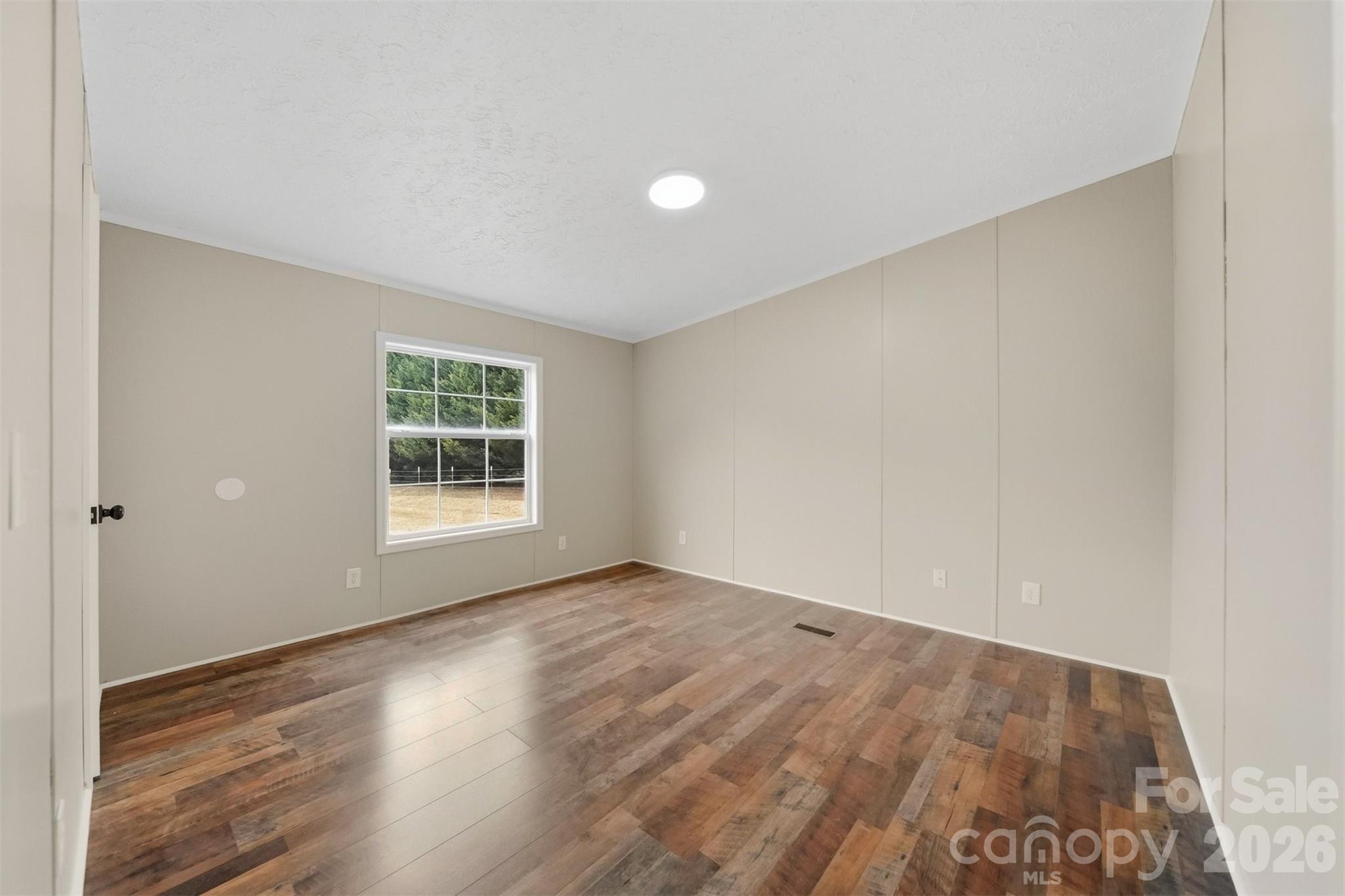 3150 Cranberry Road Boonville, NC 27011 - Photo 28 of 45 an empty room with wooden floor and windows