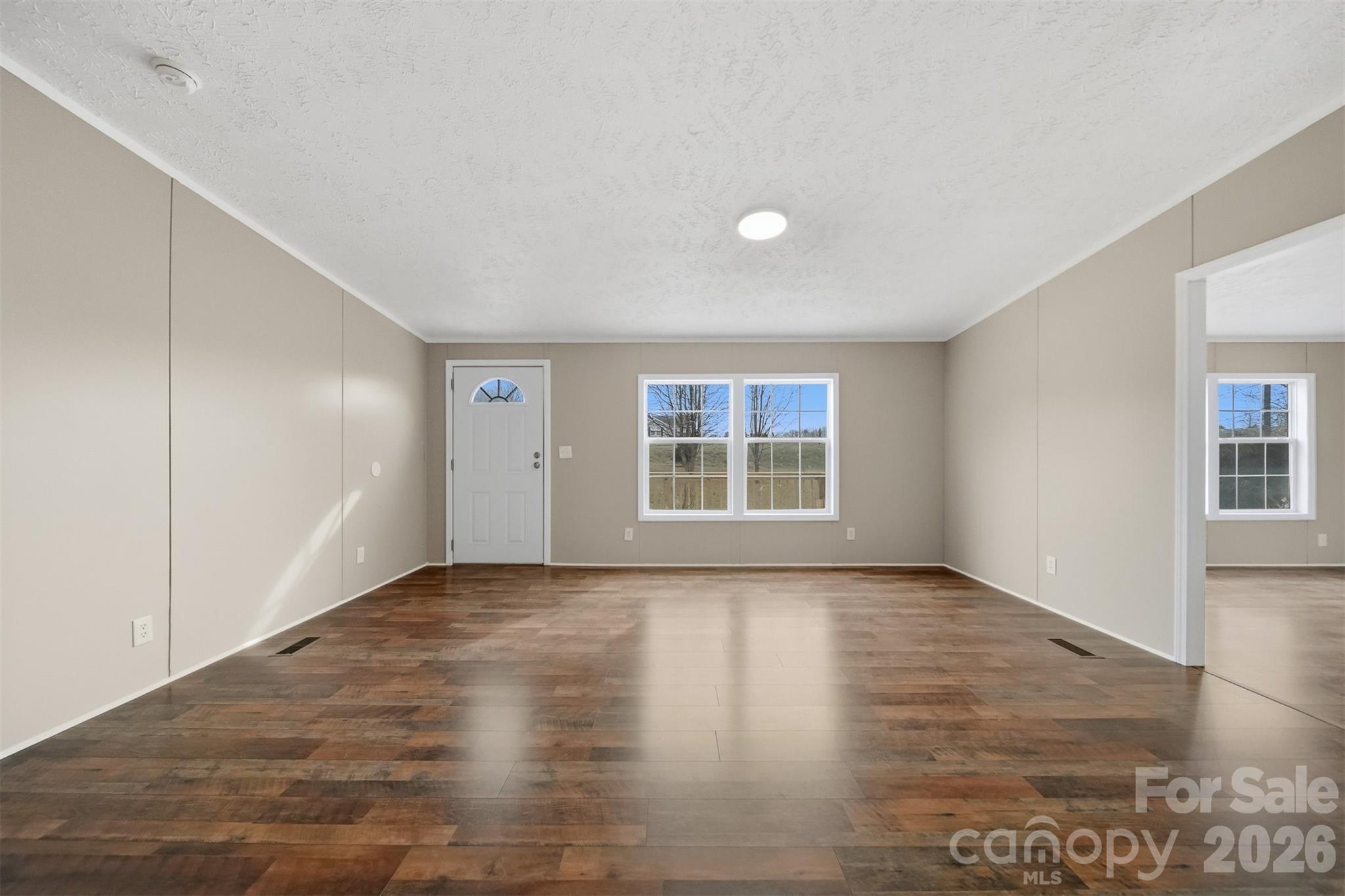 3150 Cranberry Road Boonville, NC 27011 - Photo 6 of 45 a view of an empty room with a window and wooden floor